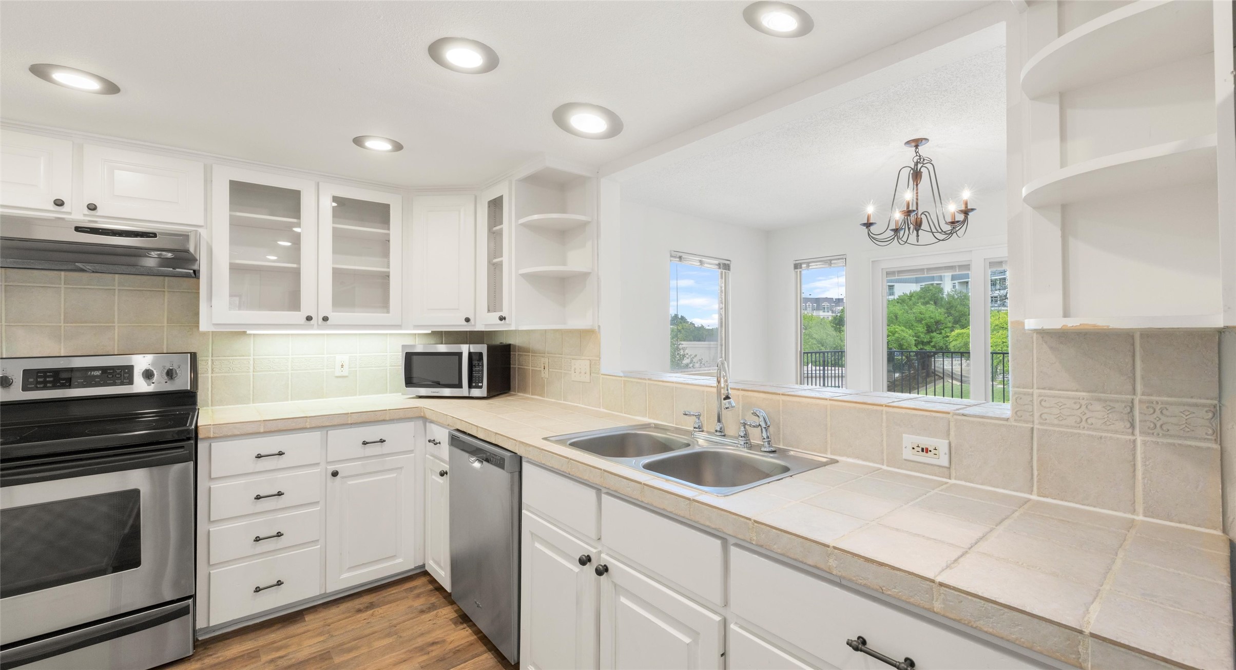 2918 Ranch Road 620 North, Unit C122 Austin, TX 78734 - Photo 4 of 36 The property features a kitchen with white cabinetry, stainless steel appliances, and tile countertops