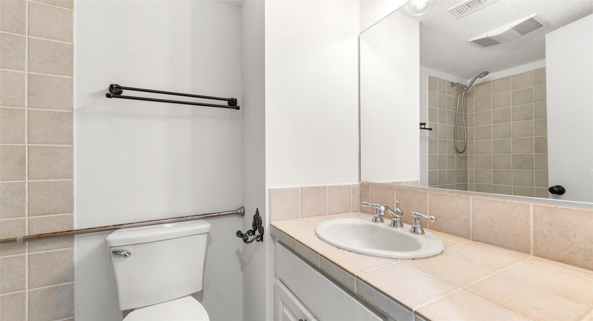 2918 Ranch Road 620 North, Unit C122 Austin, TX 78734 - Photo 10 of 36 Bathroom featuring a vanity with a tiled countertop and an integrated sink, a toilet, and a shower with tiled walls