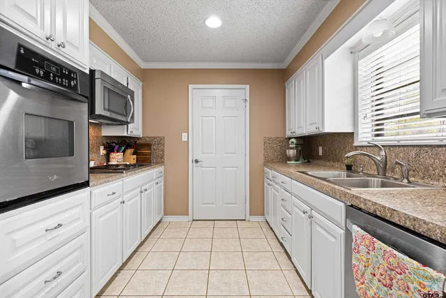 a kitchen with stainless steel appliances granite countertop a sink and a stove