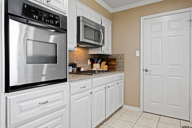 a kitchen with white cabinets and black appliances