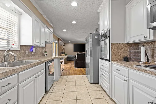 a kitchen with kitchen island granite countertop a sink appliances cabinets and counter space