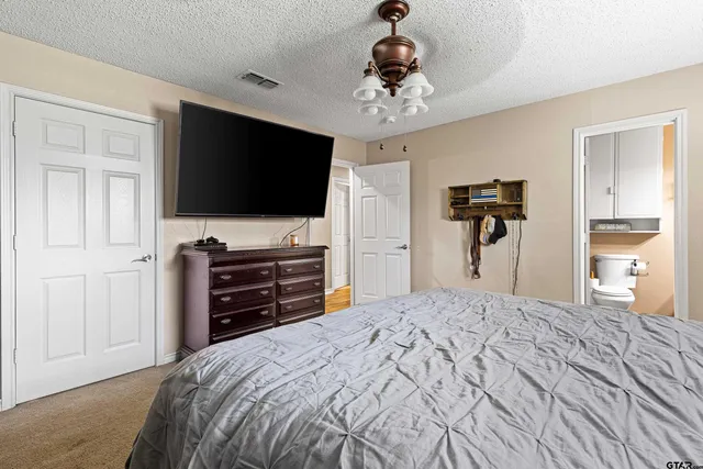a bedroom with a bed and a flat screen tv in white cabinets