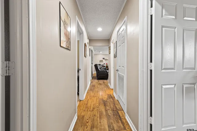 a view of a hallway with wooden floor and staircase