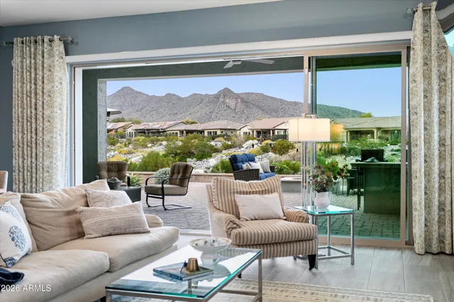 a living room with furniture a lamp and a floor to ceiling window
