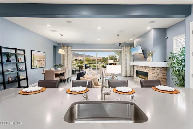 a kitchen with stainless steel appliances kitchen island granite countertop a refrigerator a sink dishwasher a stove and white cabinets with wooden floor