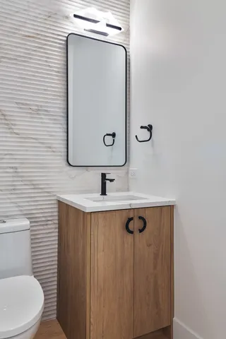 a bathroom with a sink mirror vanity and toilet