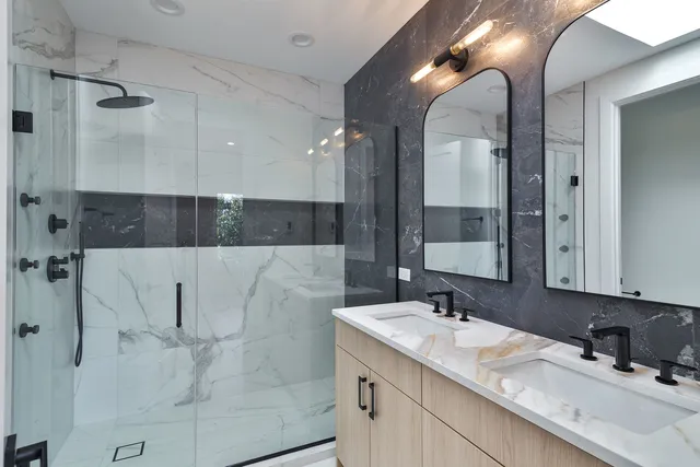 a bathroom with a double vanity sink mirror and shower