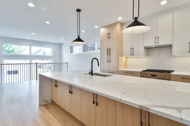 a kitchen with stainless steel appliances granite countertop a sink a window and a kitchen island