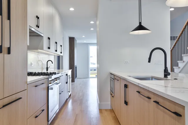 a kitchen with stainless steel appliances granite countertop a sink stove and cabinets