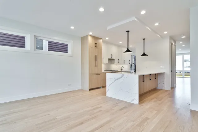 a large white kitchen with a large counter top and stainless steel appliances