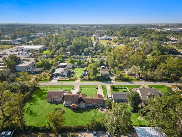an aerial view of residential houses with outdoor space and trees