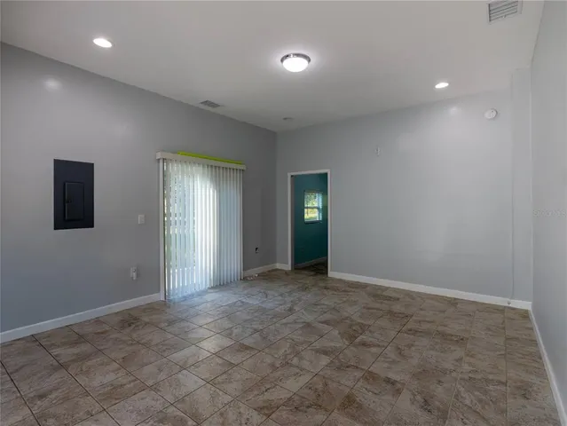 an empty room with entrance and windows