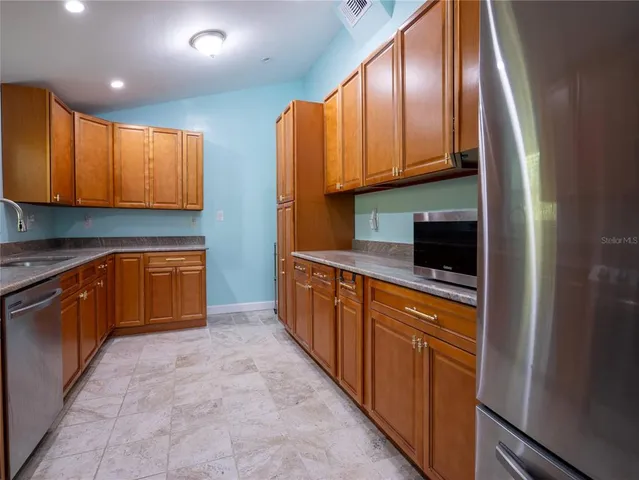 a kitchen with stainless steel appliances granite countertop wooden cabinets a sink and dishwasher