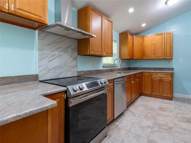 a kitchen with stainless steel appliances granite countertop a stove a sink and a microwave