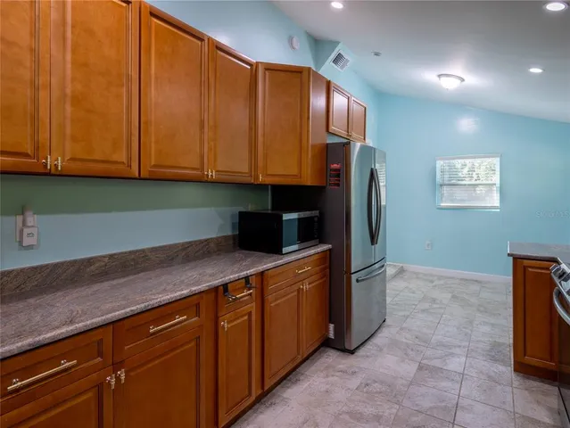 a kitchen with stainless steel appliances granite countertop a refrigerator and a sink