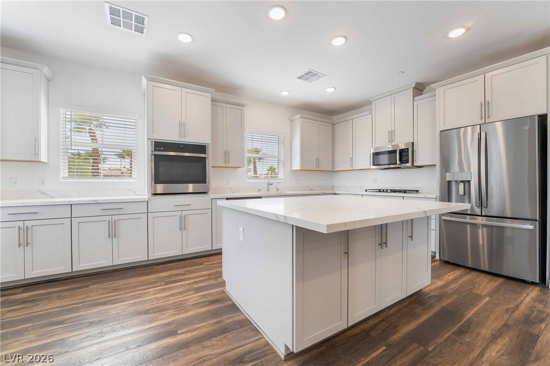 2555 Hampton Road, Unit 10202 Henderson, NV 89052 - Photo 11 of 35 Rich wood floors contrast with pristine white cabinetry and a generous center island.