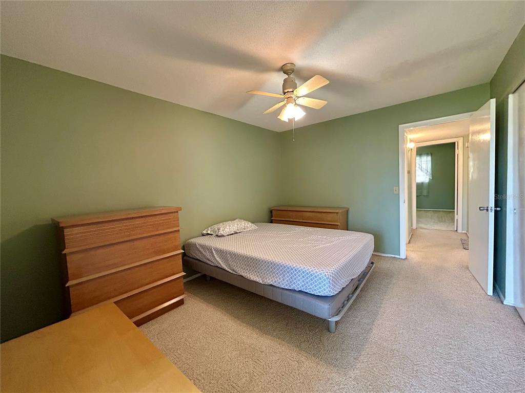 2072 Australia Way West, Unit 32 Clearwater, FL 33763 - Photo 15 of 47 a bedroom with a bed and a chandelier