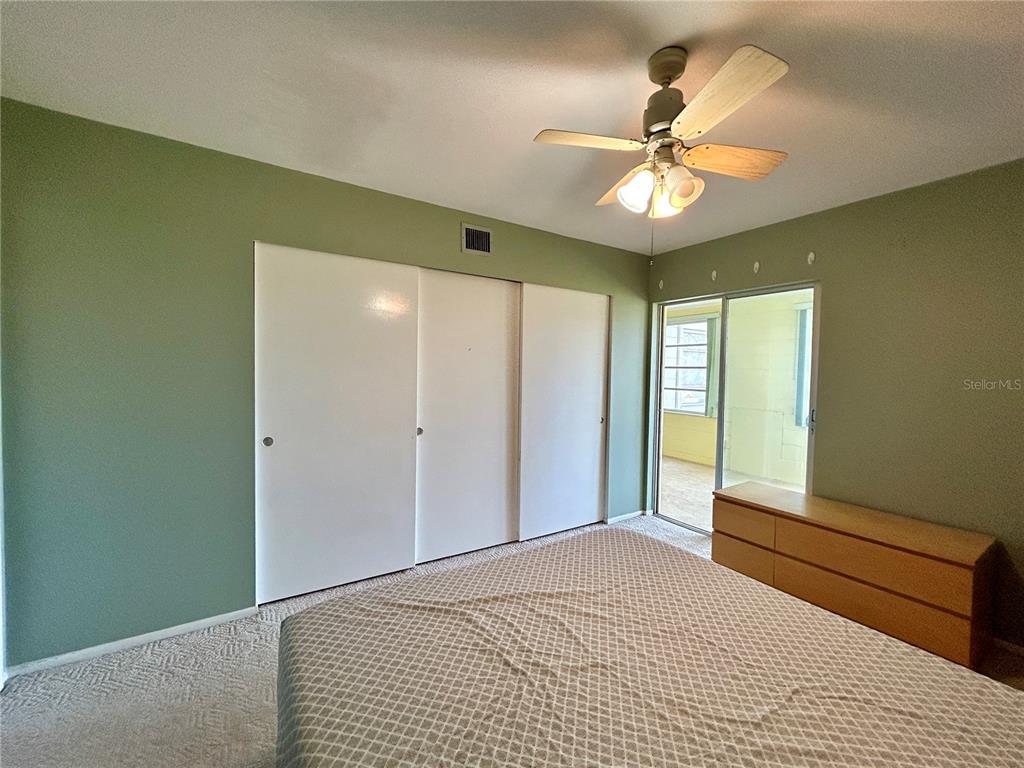 2072 Australia Way West, Unit 32 Clearwater, FL 33763 - Photo 17 of 47 a bedroom with a large bed and a chandelier fan