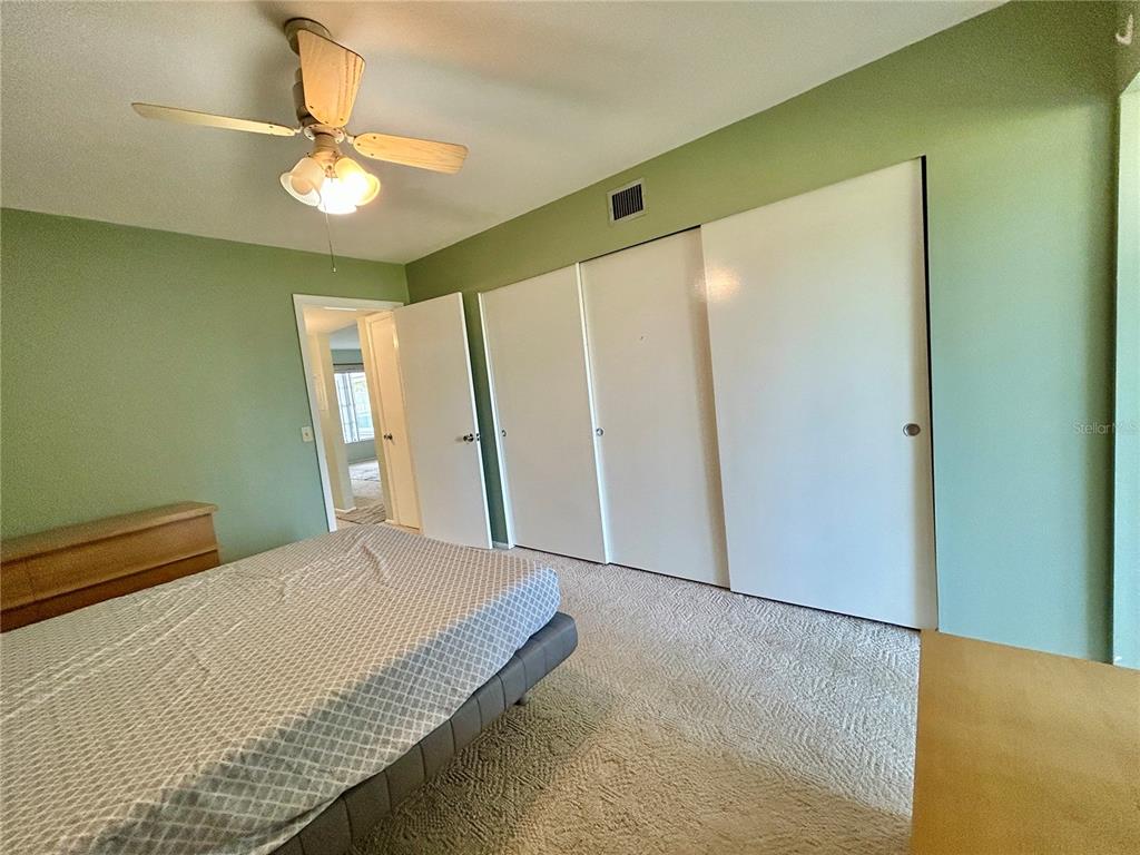 2072 Australia Way West, Unit 32 Clearwater, FL 33763 - Photo 18 of 47 a bedroom with a bed window and a chandelier