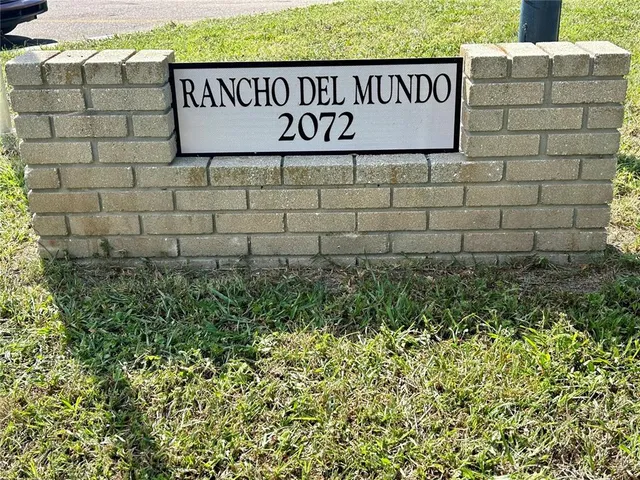 a sign broad in front of a brick wall