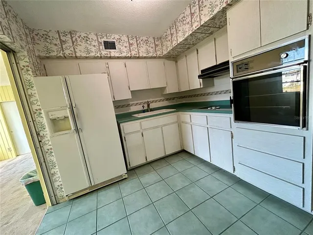 a kitchen with stainless steel appliances a sink and a microwave