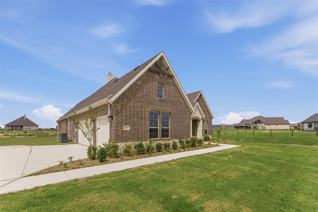 2433 Meteor Drive Krum, TX 76249 - Photo 3 of 29 Brick exterior with stone accents, featuring a prominent front gable and a two-car garage