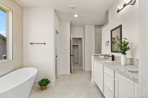 a bathroom with a granite countertop sink a mirror and a bathtub