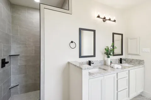 a bathroom with a granite countertop sink and a mirror