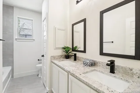 a bathroom with a tub shower and sink