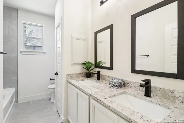 a bathroom with a tub shower and sink