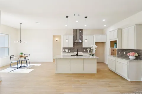 a kitchen with stainless steel appliances kitchen island sink refrigerator and cabinets
