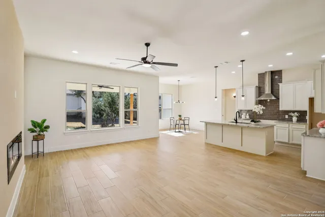 a large living room with stainless steel appliances kitchen island a large counter top and wooden floors