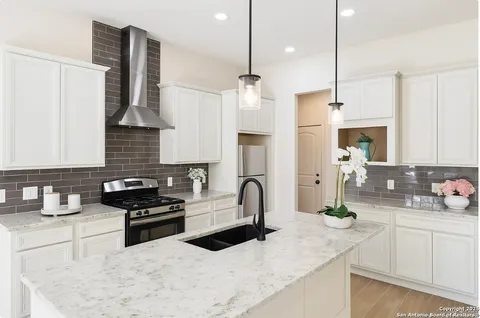 a kitchen with stainless steel appliances granite countertop a sink a stove and a refrigerator