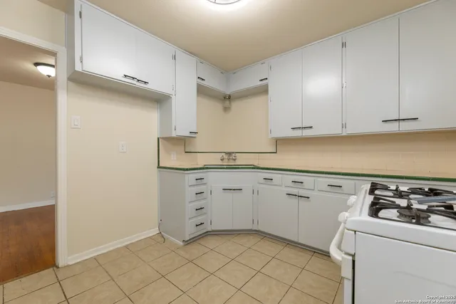 a kitchen with granite countertop white cabinets and white appliances
