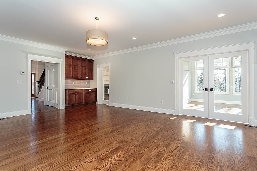 180 Ridge Street Winchester, MA 01890 - Photo 16 of 30 a view of an empty room with wooden floor and a kitchen