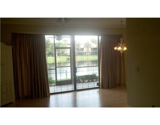 5771 Coach House Circle, Unit B Boca Raton, FL 33486 - Photo 3 of 20 a open hall with a floor to ceiling window and wooden floor