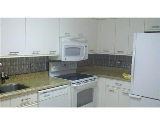 5771 Coach House Circle, Unit B Boca Raton, FL 33486 - Photo 8 of 20 a kitchen with a sink stove and cabinets