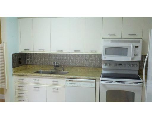 5771 Coach House Circle, Unit B Boca Raton, FL 33486 - Photo 9 of 20 a kitchen with a stove and white cabinets