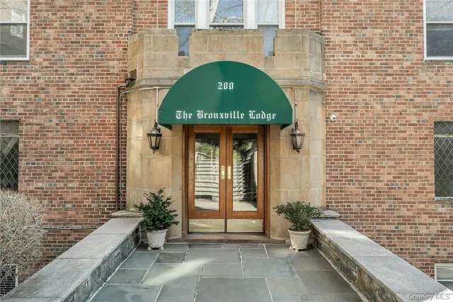 a front view of a house with potted plants
