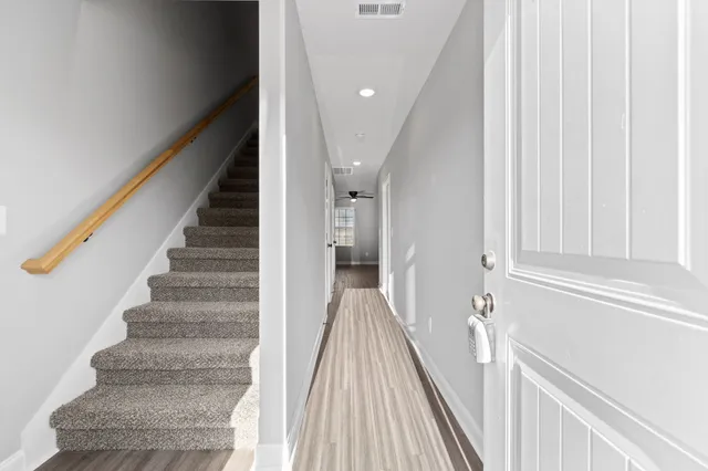 a view of a hallway with wooden floor and staircase