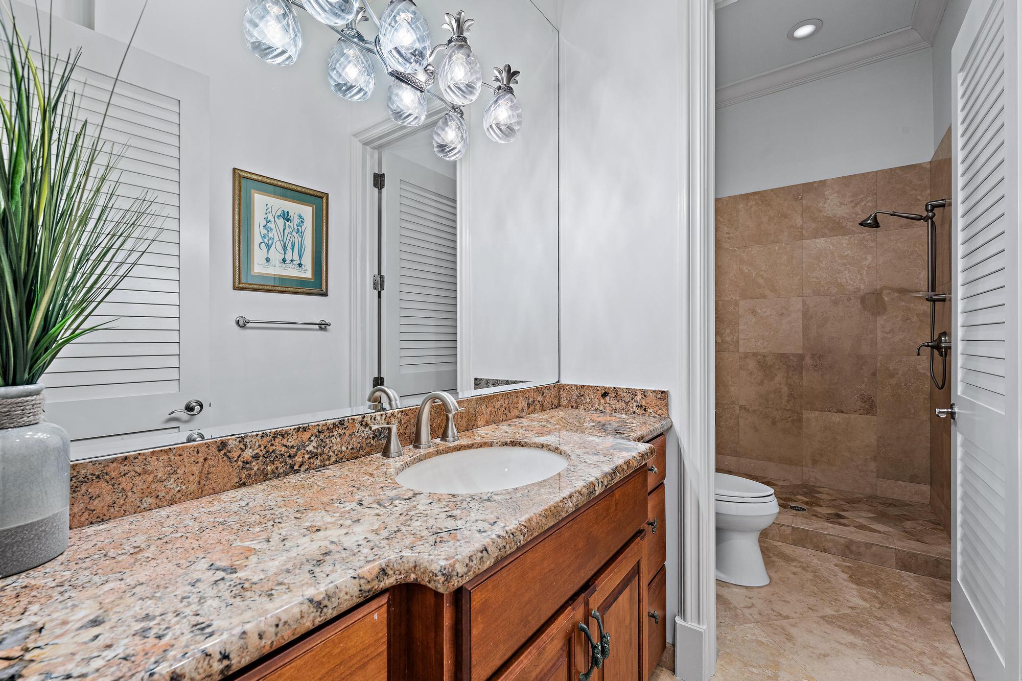 613 South Beach Road Jupiter, FL 33469 - Photo 71 of 74 a bathroom with a granite countertop sink a toilet a mirror and shower