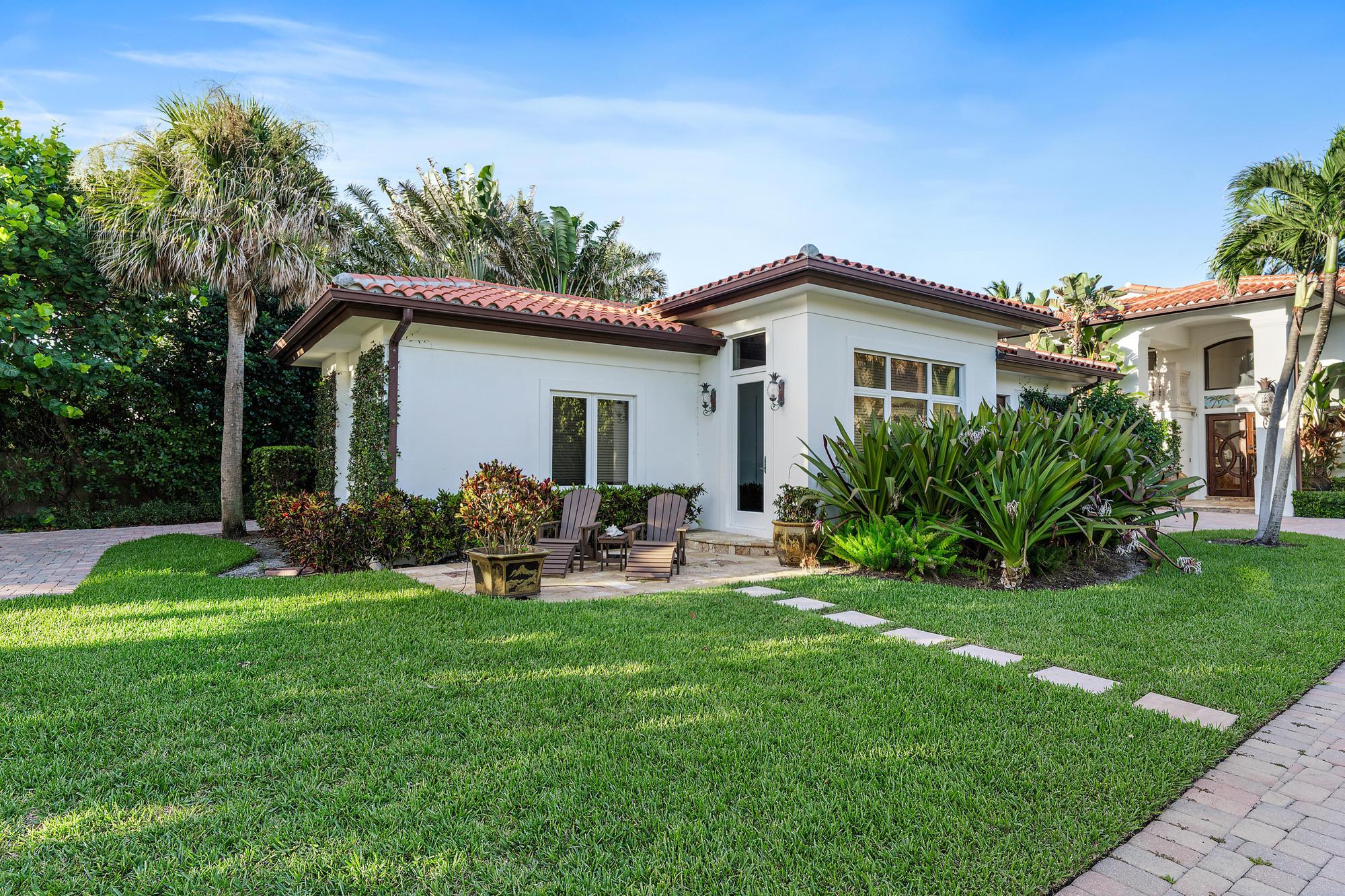 613 South Beach Road Jupiter, FL 33469 - Photo 72 of 74 a backyard of a house with table and chairs plants and large tree