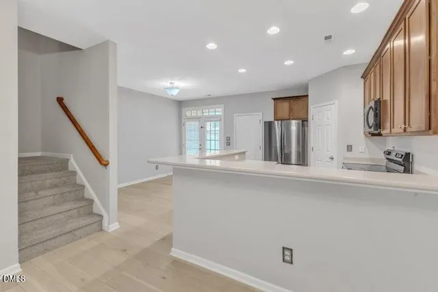 a kitchen with stainless steel appliances a refrigerator sink and microwave