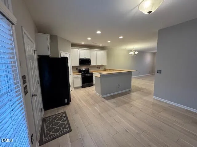 a view of kitchen with refrigerator stove and wooden cabinets