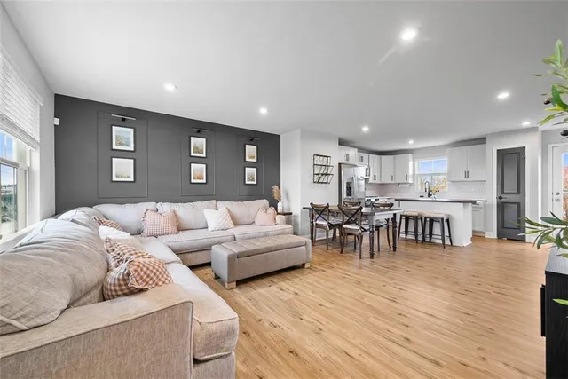 a living room with furniture and a dining table with kitchen view