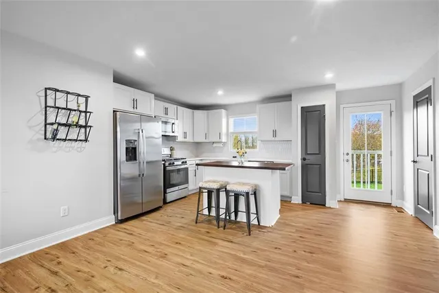 a kitchen with white cabinets and stainless steel appliances