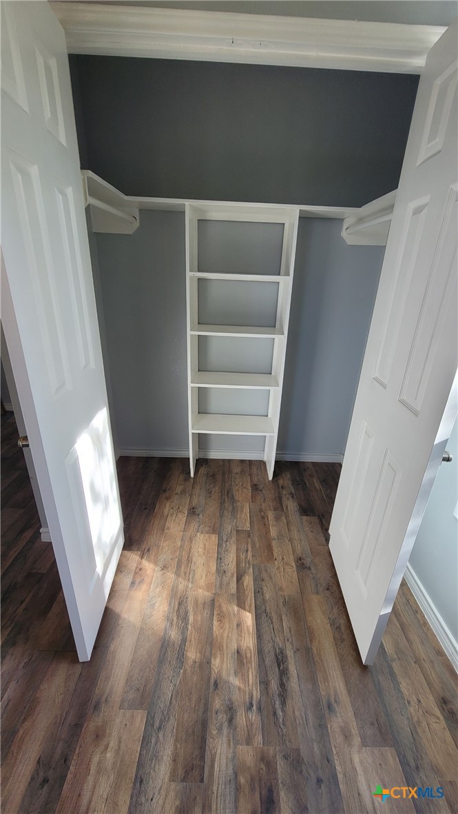 127-129 McAdams Road Goliad, TX 77963 - Photo 19 of 33 a view of walk in closet with wooden floor and stairs
