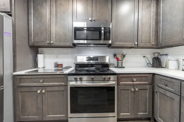 a kitchen with granite countertop white cabinets and stainless steel appliances