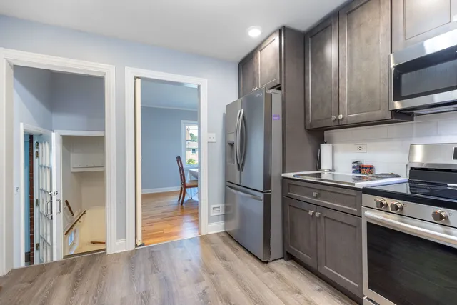 a kitchen with stainless steel appliances wooden floor sink and wooden cabinets