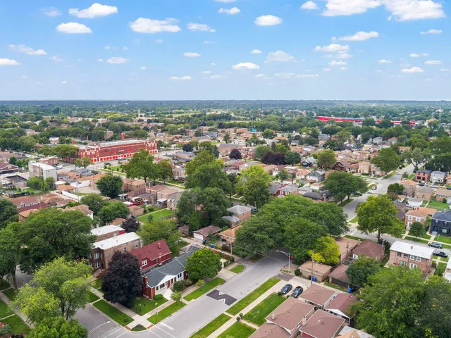a view of a house with a yard and palm trees